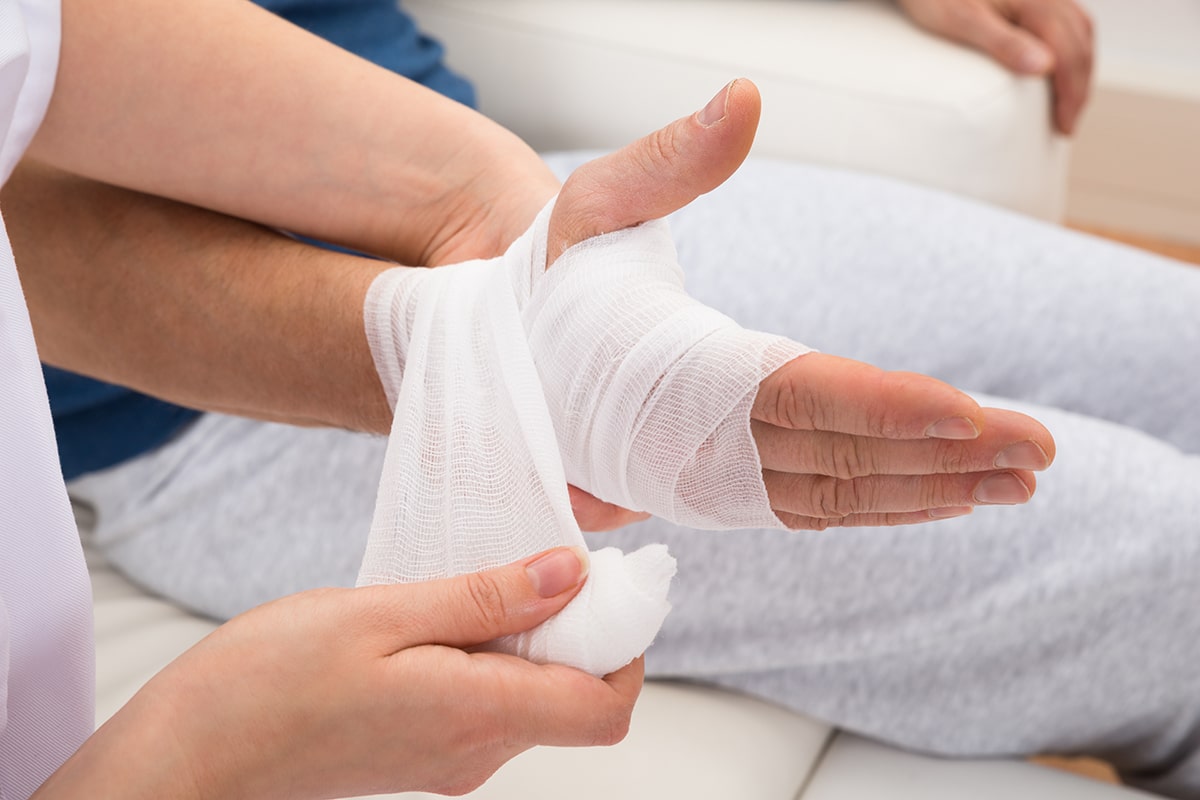Close-up Of A Nurse Bandaging Patient's Hand